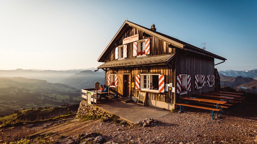 Wanderpaar beim Eintrag ins Gipfelbuch auf dem Grossen Mythen. Armin Schelbert in der Berghuette am Nachfuehren des Gipfelbuches. Foto: Schweiz Tourismus